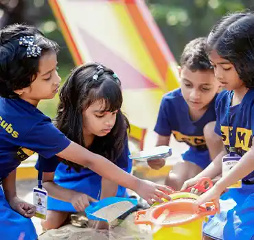 Four Students of Asoka World School playing in sand pit